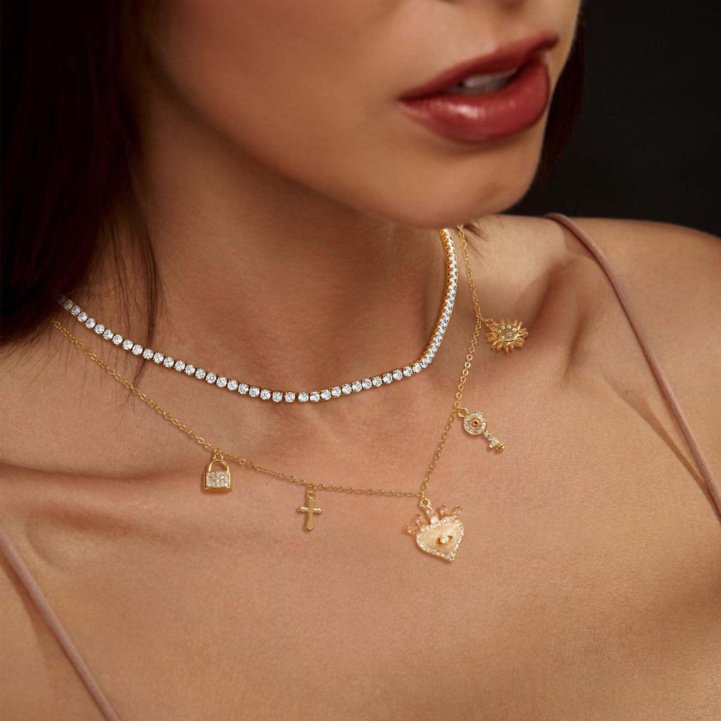 Collier tennis zircons argenté porté avec des colliers dorés à breloques